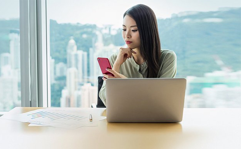 女企业家透过香港汇丰Business Express手机应用程序登入商务网上理财