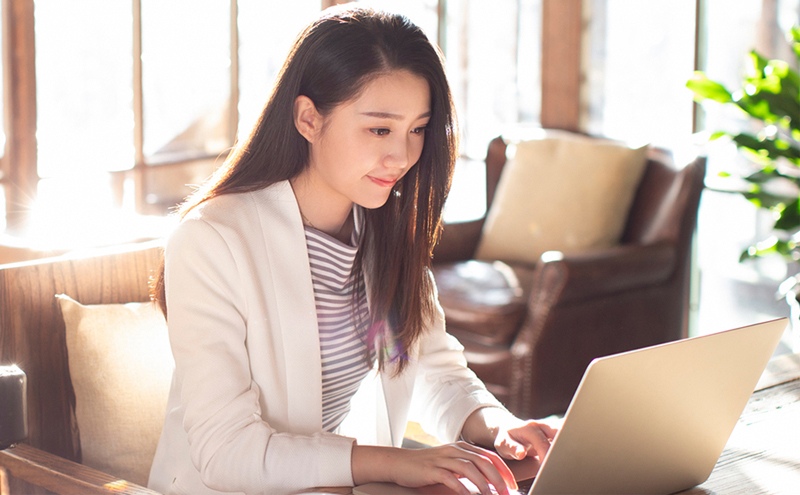 女企业家利用笔记本电脑关注汇丰香港商业理财WeChat 官方账号 